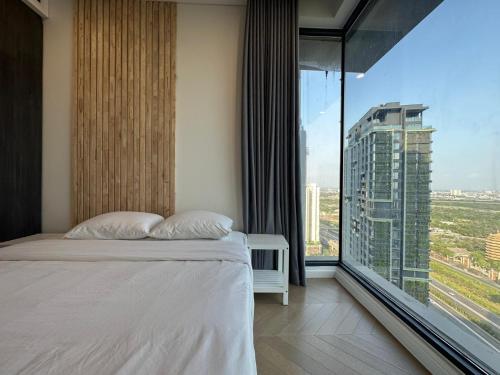 um quarto de hotel com uma cama e uma grande janela em luxurious apartment close to city center em Ho Chi Minh