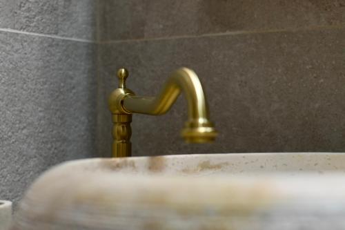 a bathroom sink with a gold faucet at Villa Marinero in Ulcinj