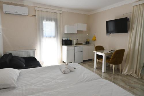 a bedroom with a white bed and a kitchen at JERUSALEM luks מלון Kutaisi in Kutaisi