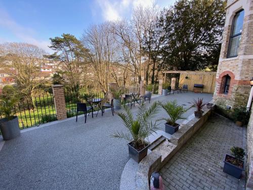 a courtyard with chairs and potted plants next to a building at The Regency - Historic residences by the sea in Ilfracombe