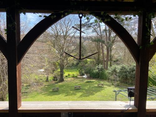 an arched window looking out at a park with benches at The Regency in Ilfracombe