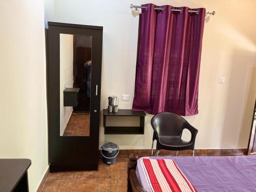 1 dormitorio con cama y cortina púrpura en Panchatattva Homestay, en Belmannu