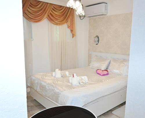 a white bed with two hello kitty towels on it at JERUSALEM luks מלון Kutaisi in Kutaisi