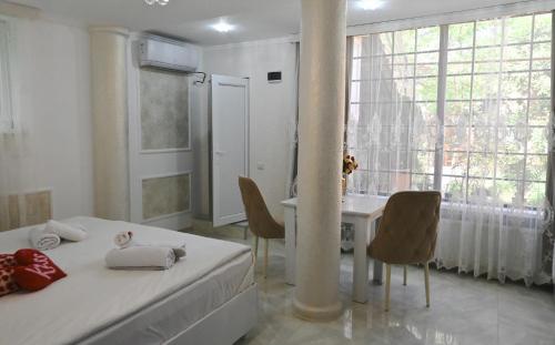 JERUSALEM merkaz Hotel Kutaisi في كوتايسي: غرفة نوم بسرير وطاولة مع كراسي