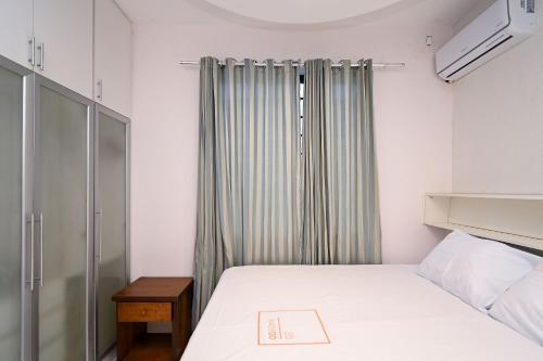 um pequeno quarto com uma cama e uma janela em Casa Espaçosa com Jacuzzi e Churrasqueira RAU409 em Goiânia
