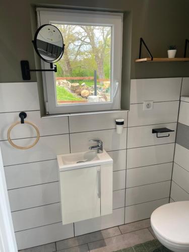 a small bathroom with a sink and a window at Gîte de campagne in Yvetot Bocage