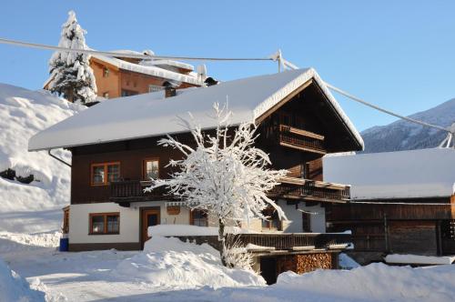 una casa cubierta de nieve en el frente en Haus ROSE, en Sankt Jakob in Defereggen
