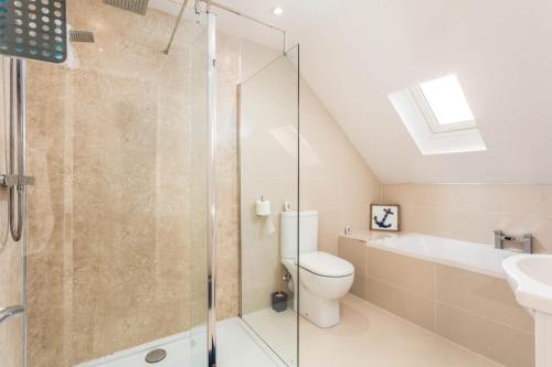 a bathroom with a shower and a toilet and a sink at 56 Hawkhill Avenue in Ayr