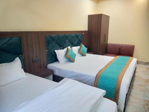 une chambre d'hôtel avec deux lits et une chaise dans l'établissement Amigo Rooms, à Rishikesh