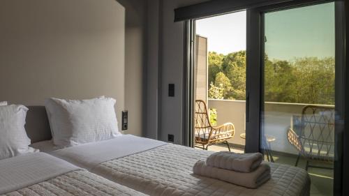 a bedroom with a white bed and a balcony at CHE BELLO NATURE in Preveza
