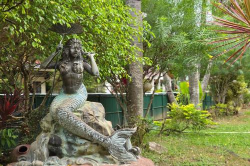 a statue of a mermaid sitting on a rock at Grand Villa Laguna in Manila