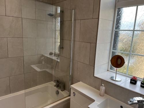 a bathroom with a shower and a tub and a sink at Steeple View - A two bedroom 18th century cottage. in Leeds