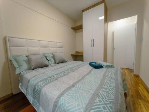 a bedroom with a large bed with a blue bag on it at Apartamento Ótimo ! VLP62 in Maringá