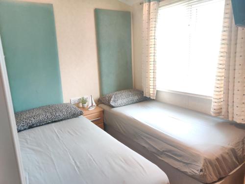 a bedroom with two beds next to a window at Rockley Park Private Holiday Homes in Poole