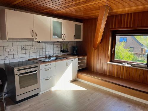 a kitchen with white cabinets and a window at Gemütliches Zweibett-Zimmer in Schleswig-Holstein - ideal für Monteure und Geschäftsreisende, Gemeinschaftsbad Zimmer Nr 5 in Groß Vollstedt