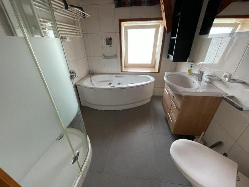 a bathroom with a tub and a toilet and a sink at Gemütliches Zweibett-Zimmer in Schleswig-Holstein - ideal für Monteure und Geschäftsreisende, Gemeinschaftsbad Zimmer Nr 5 in Groß Vollstedt