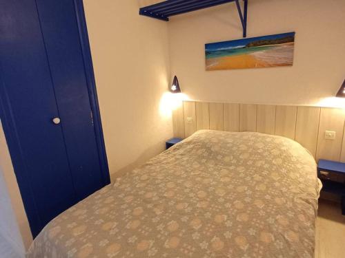 um quarto com uma cama e uma porta azul em Appartement Balaruc-les-Bains, 1 pièce, 2 personnes - FR-1-571-24 em Balaruc-les-Bains