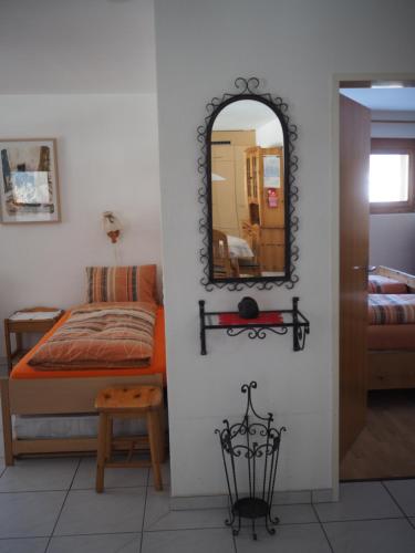 sypialnia z lustrem, łóżkiem i stołem w obiekcie Sut baselgia w mieście Andeer