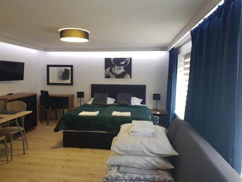 ein Schlafzimmer mit einem Bett, einem Sofa und einem Tisch in der Unterkunft Villa Azalia in Łeba