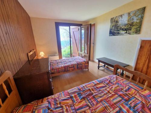 une chambre d'hôtel avec deux lits et une fenêtre dans l'établissement Appartement 4 pers, 2 chambres, pied des pistes, balcon sud - Saint-Michel-de-Chaillol - FR-1-393-139, à Saint-Michel-de-Chaillol