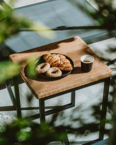 a wooden table with a plate of pastries on it at CHE BELLO NATURE in Preveza