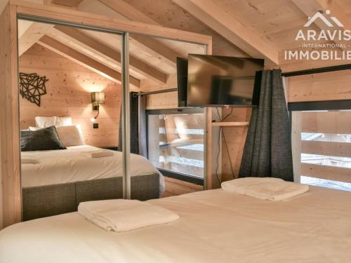 een slaapkamer met 2 bedden en een tv in een kamer bij Chalet Le Grand-Bornand, 3 pièces, 8 personnes - FR-1-391-168 in Le Grand-Bornand
