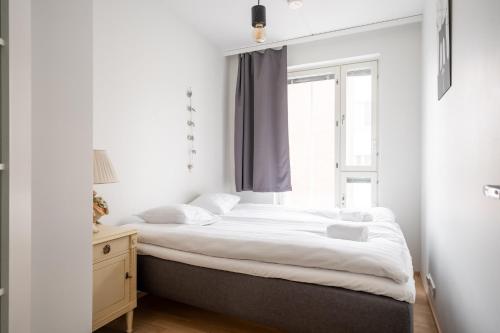 ein Schlafzimmer mit einem großen Bett und einem Fenster in der Unterkunft 2 BR apartment with Sauna, Free parking and center location in Tampere