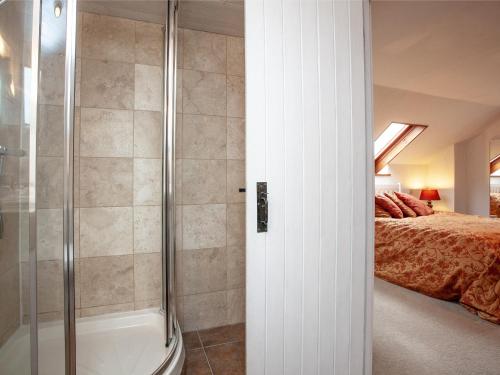 a bathroom with a shower and a bed at Hayden Farm in Culmstock