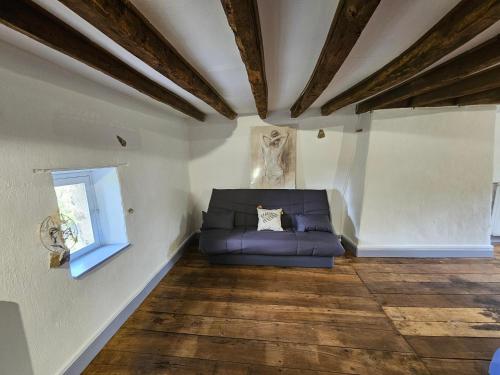 a living room with a blue couch and a window at La villa aux volets bleus in Saint-Étienne-de-Fursac