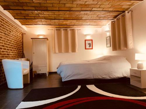 a bedroom with a bed and a brick wall at Studio 29 m2 proche La Défense et Arena in Nanterre