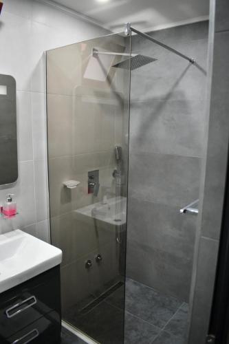 a shower with a glass door next to a sink at Villa Marinero in Ulcinj