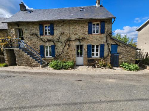 an old stone house with blue windows and blue shutters at La villa aux volets bleus in Saint-Étienne-de-Fursac