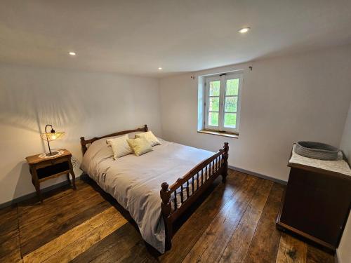 Schlafzimmer mit einem Bett und einem Fenster in der Unterkunft La villa aux volets bleus in Saint-Étienne-de-Fursac
