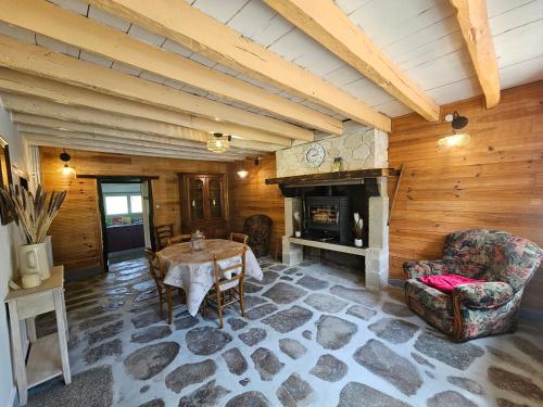 a living room with a table and a fireplace at La villa aux volets bleus in Saint-Étienne-de-Fursac