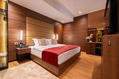 a bedroom with a large bed with wooden walls at Hotel De‘Andros Virpazar in Virpazar