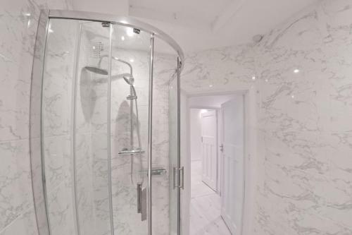 a bathroom with a shower with a glass door at 2 Bed Apartment In Wembley, Ealing, London in Perivale
