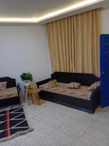 uma sala de estar com duas camas e uma mesa em Asma em Houmt Souk