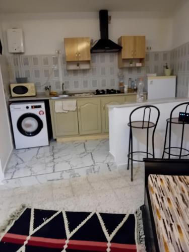 uma cozinha com um fogão e uma máquina de lavar roupa em Asma em Houmt Souk