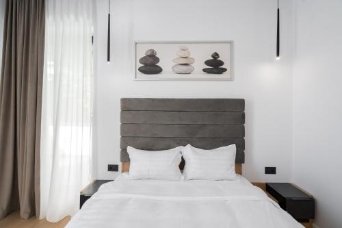 um quarto com uma grande cama branca com almofadas brancas em Eden I Rosetty Luxury I Moșilor em Bucareste