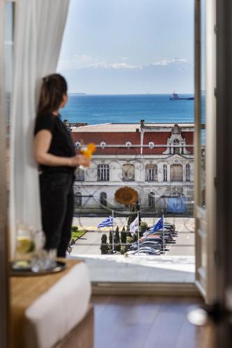 a woman looking out of a window at a building at Mediterranean Palace in Thessaloniki