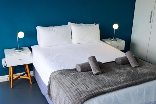 Un dormitorio con una gran cama blanca con dos mesitas de noche. en Ocean View - The House, en Knysna