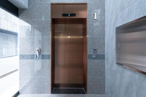 a elevator in a bathroom with a phone at Incheon Airport Guest House King in Incheon
