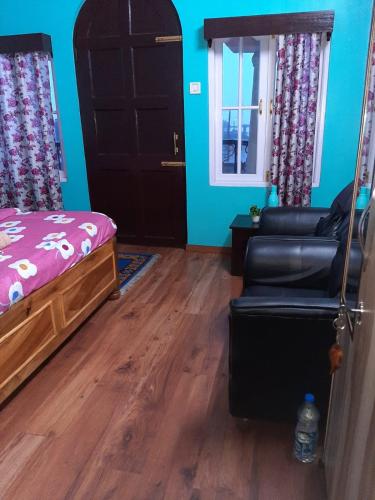 ein Schlafzimmer mit einem Bett, einem Sofa und einer Tür in der Unterkunft Chewang Homestay in Darjeeling
