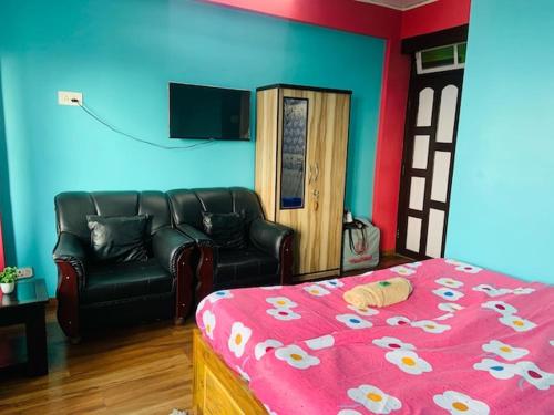 ein Schlafzimmer mit einem Bett, einem Sofa und einem TV in der Unterkunft Chewang Homestay in Darjeeling