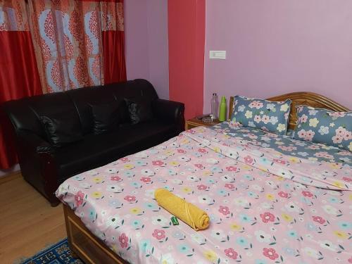 ein Schlafzimmer mit einem Bett und einem Sofa in der Unterkunft Chewang Homestay in Darjeeling