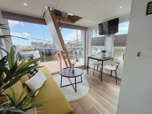 a living room with a couch and a table at Tiny lake houses near the beach and centre by Weltevreden Experience in Zeewolde