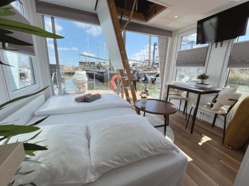 um quarto com uma cama e vista para um barco em Tiny lake houses near the beach and centre em Zeewolde