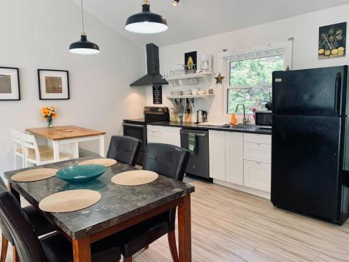 a kitchen with a table and a black refrigerator at Serene Cottage in Halifax