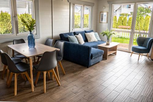 ein Wohnzimmer mit einem blauen Sofa und einem Tisch in der Unterkunft Collins Beach in Ustronie Morskie