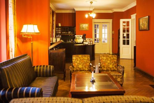ミエンジグジェにあるVilla Titinaのオレンジ色の壁のリビングルーム(テーブル、椅子付)